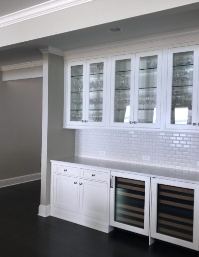 Modern kitchen with white cabinetry, subway tile backsplash, and built-in wine fridge.