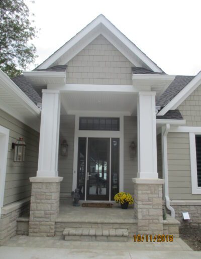Front entrance of a modern house with stone accents and white columns.