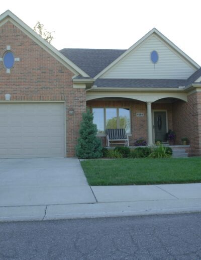 Single-story suburban home with a two-car garage and manicured lawn at dusk.